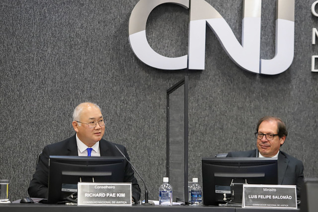 Foto mostra o conselheiro e o corregedor sentados na bancada principal do Plenário do CNJ.