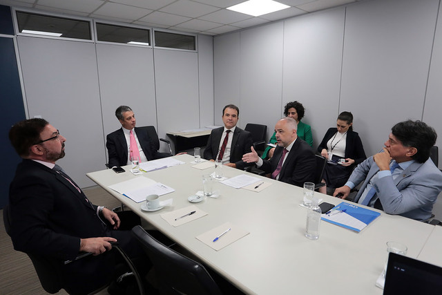 Imagem mostra reunião de cinco pessoas sentadas em uma mesa 