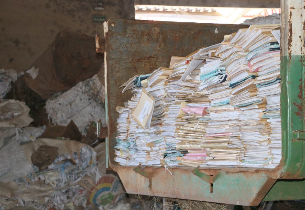 Imagem monstra pilhas de papel dentro de uma caminhão caçamba