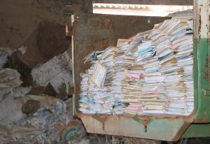 Imagem monstra pilhas de papel dentro de uma caminhão caçamba