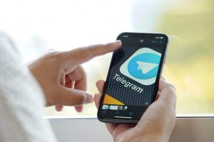 Mulher utiliza celular com aplicativo Telegram